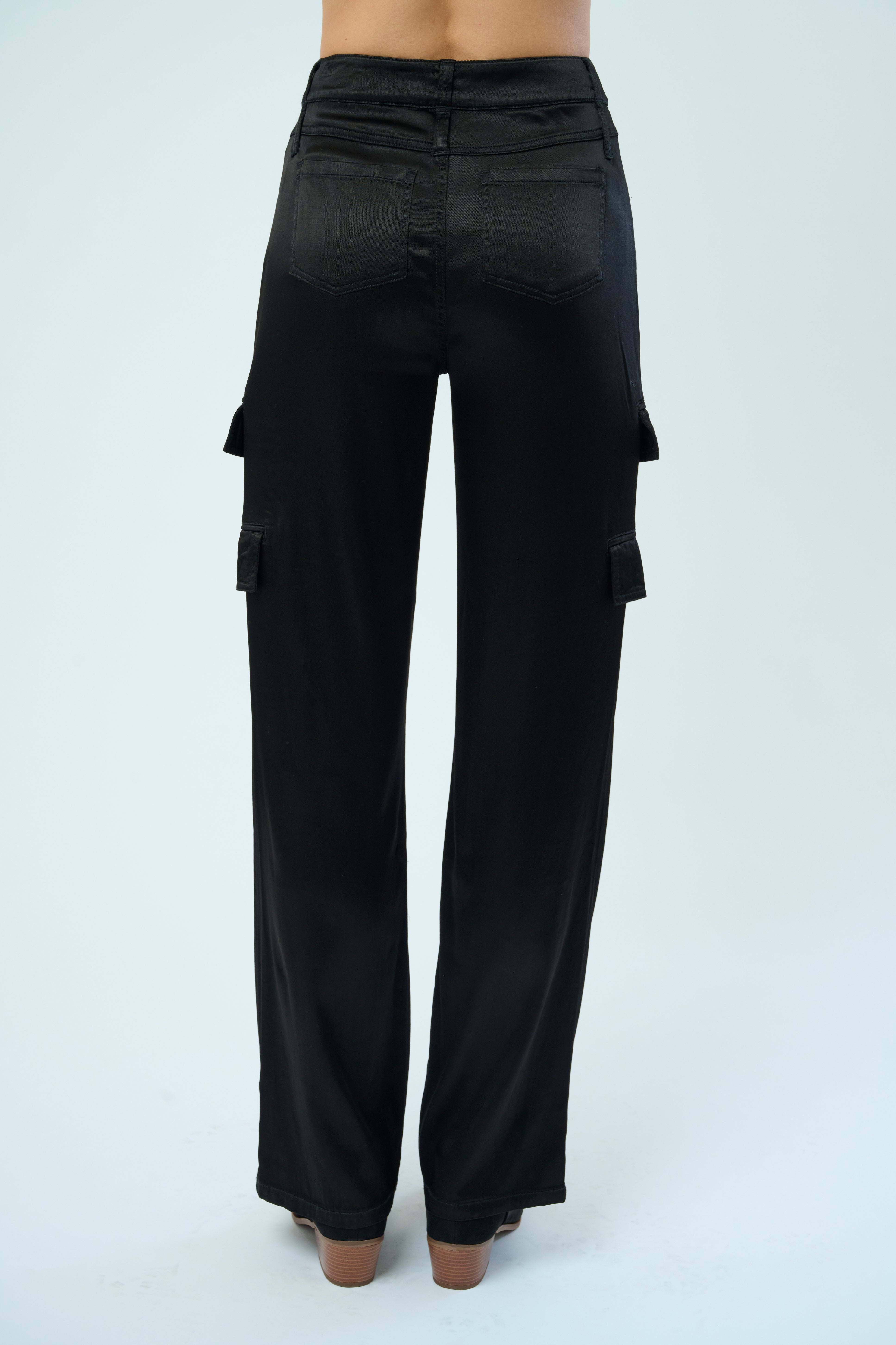 Back view of a tall female model confidently posing wearing our black colored Zendaya Stretch Viscose Satin Wide Leg Pant from Marrakech Clothing.