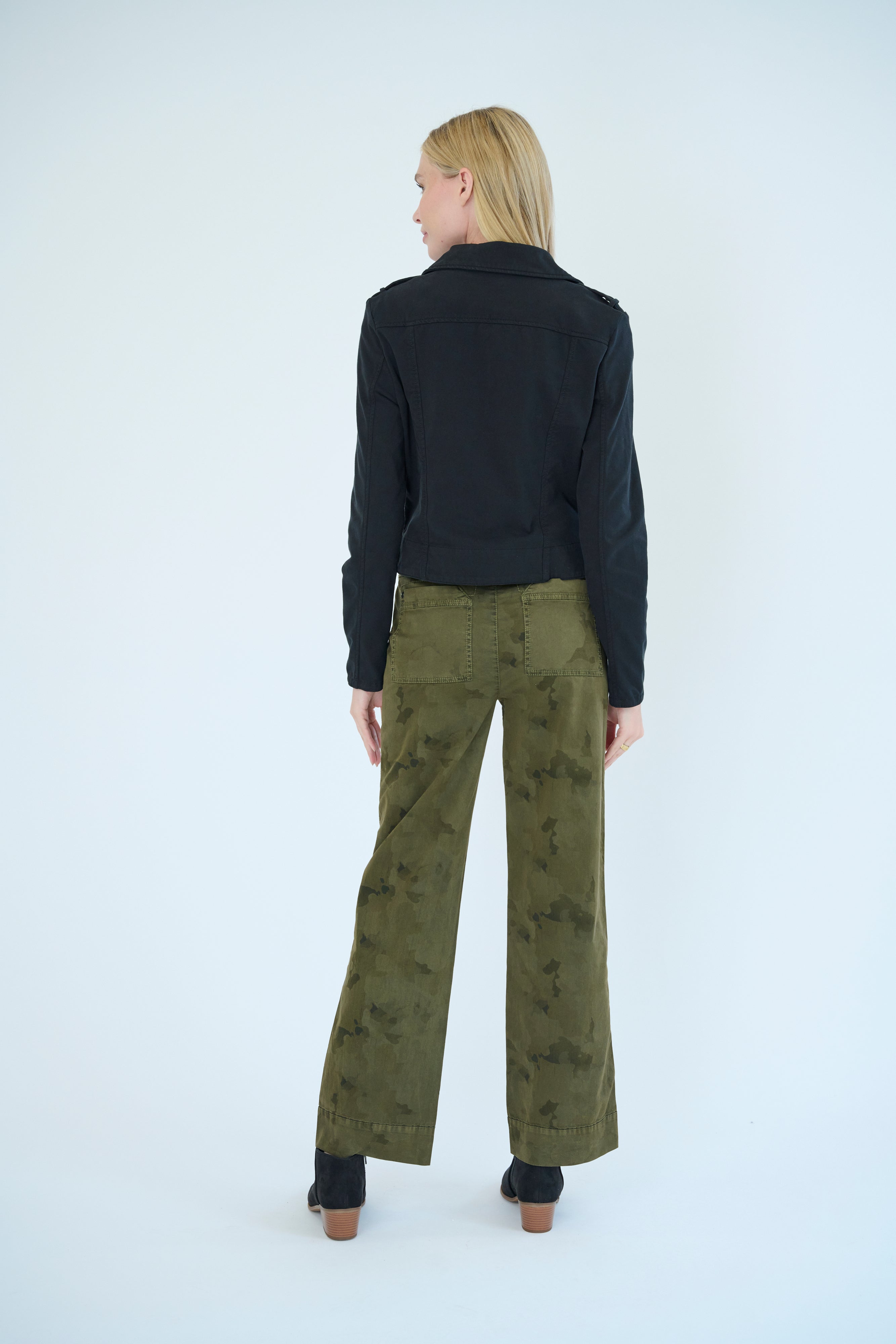 Back view of model wearing Darilyn pant in Pine Camo color and Layla Jacket in Black color