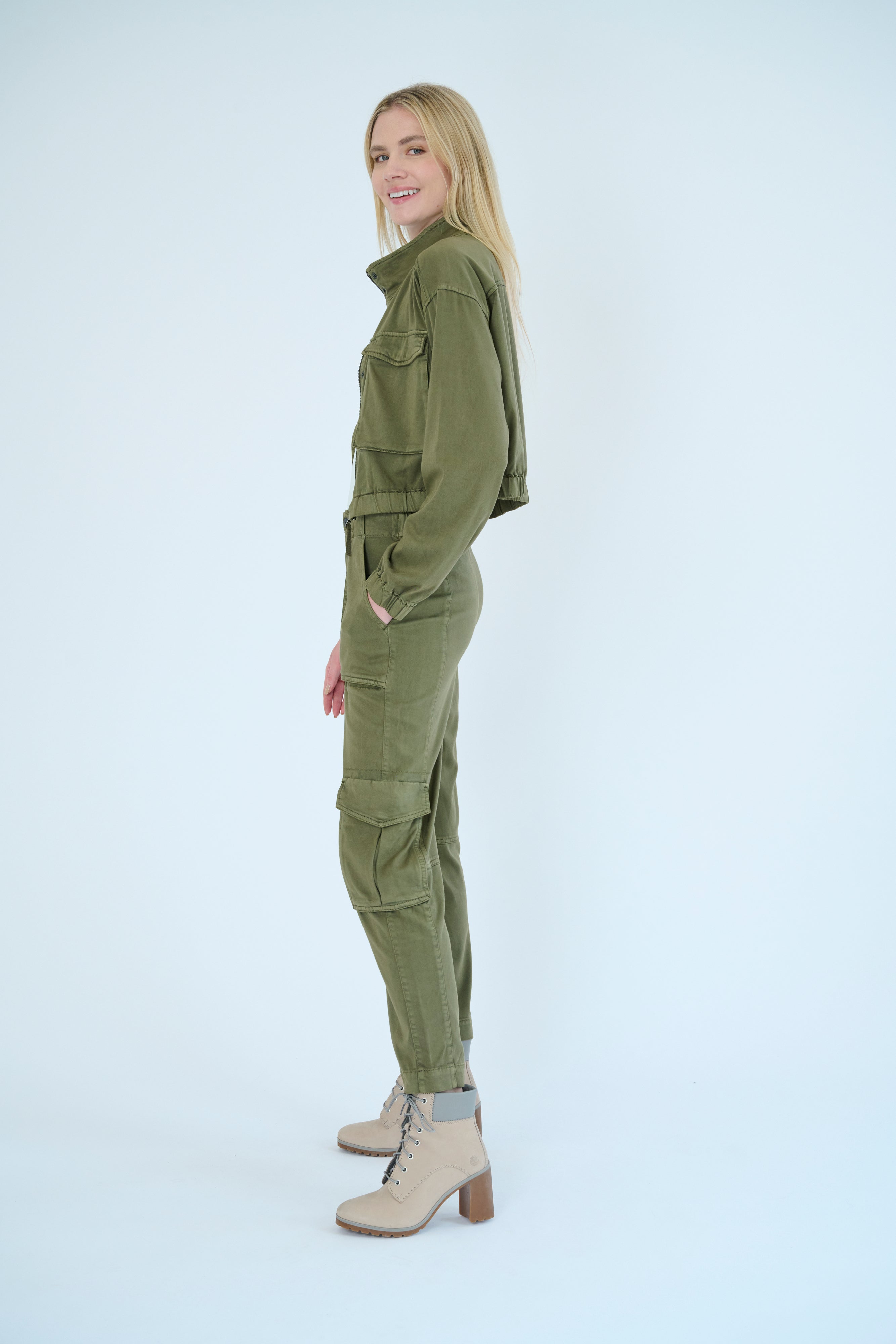 Side view of a model wearing the Nelle jacket in a Pine color.